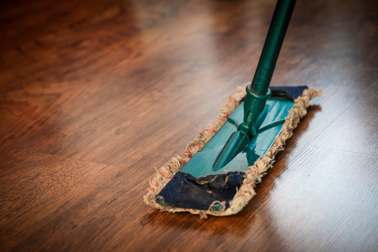 why-choose-us A detailed view of a mop cleaning a wooden floor, showing texture and pattern.